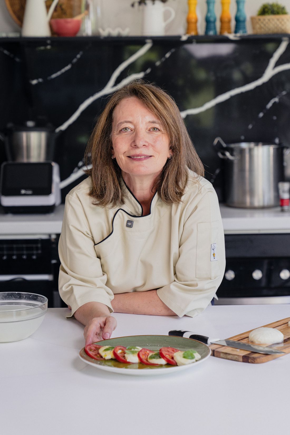 Bernardita Correa, la Maestra Quesera, en su cocina junto a una caprese recién preparada.